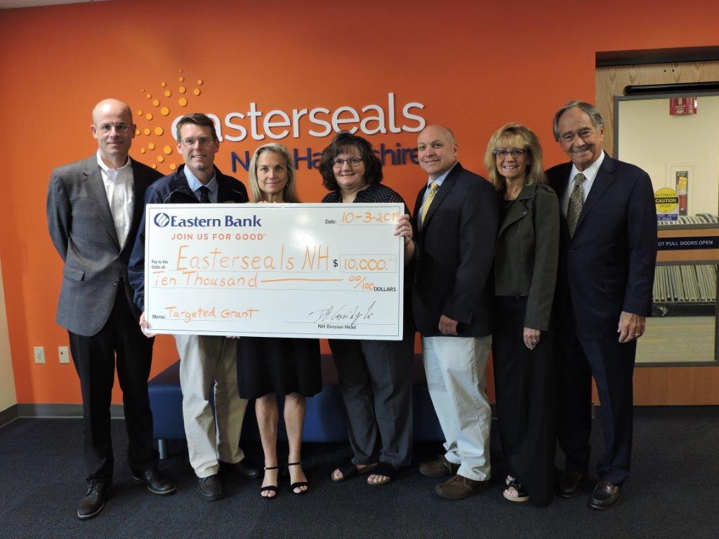 Easterseals New Hampshire and Eastern Bank representatives pose with a poster of the $10;000 check for the grant to benefit Enriching Early Childhood Development.
