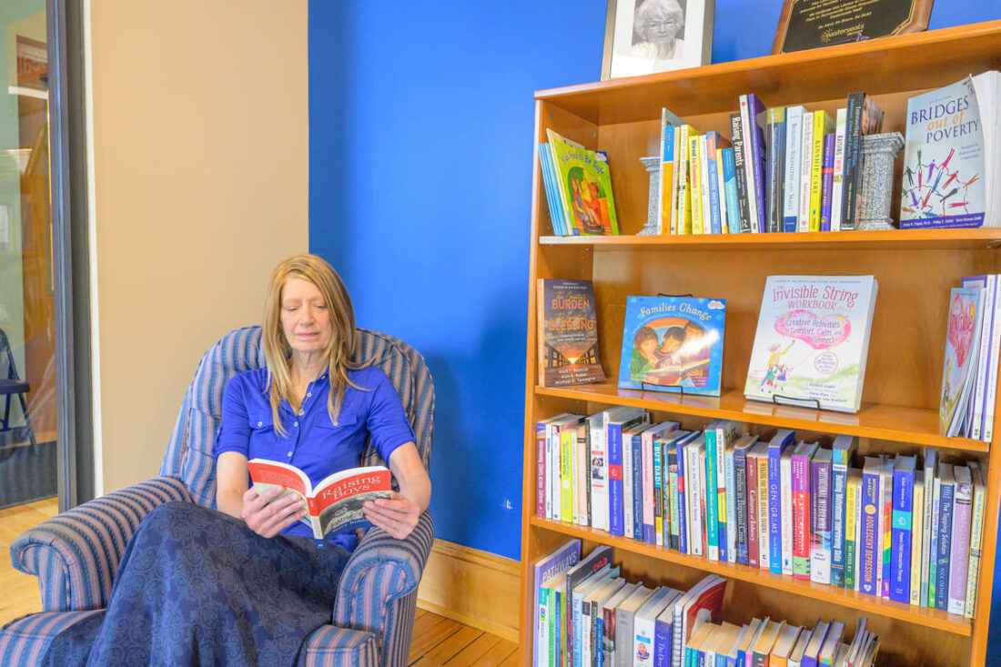 Tanya reading a book in Easterseals VT lending library.