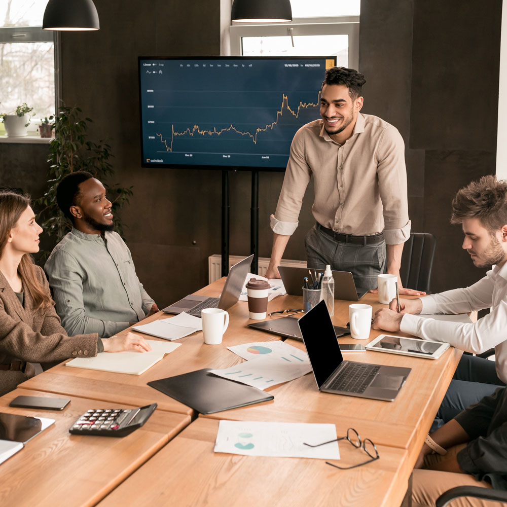 Man giving a presentation in an office to co workers. 