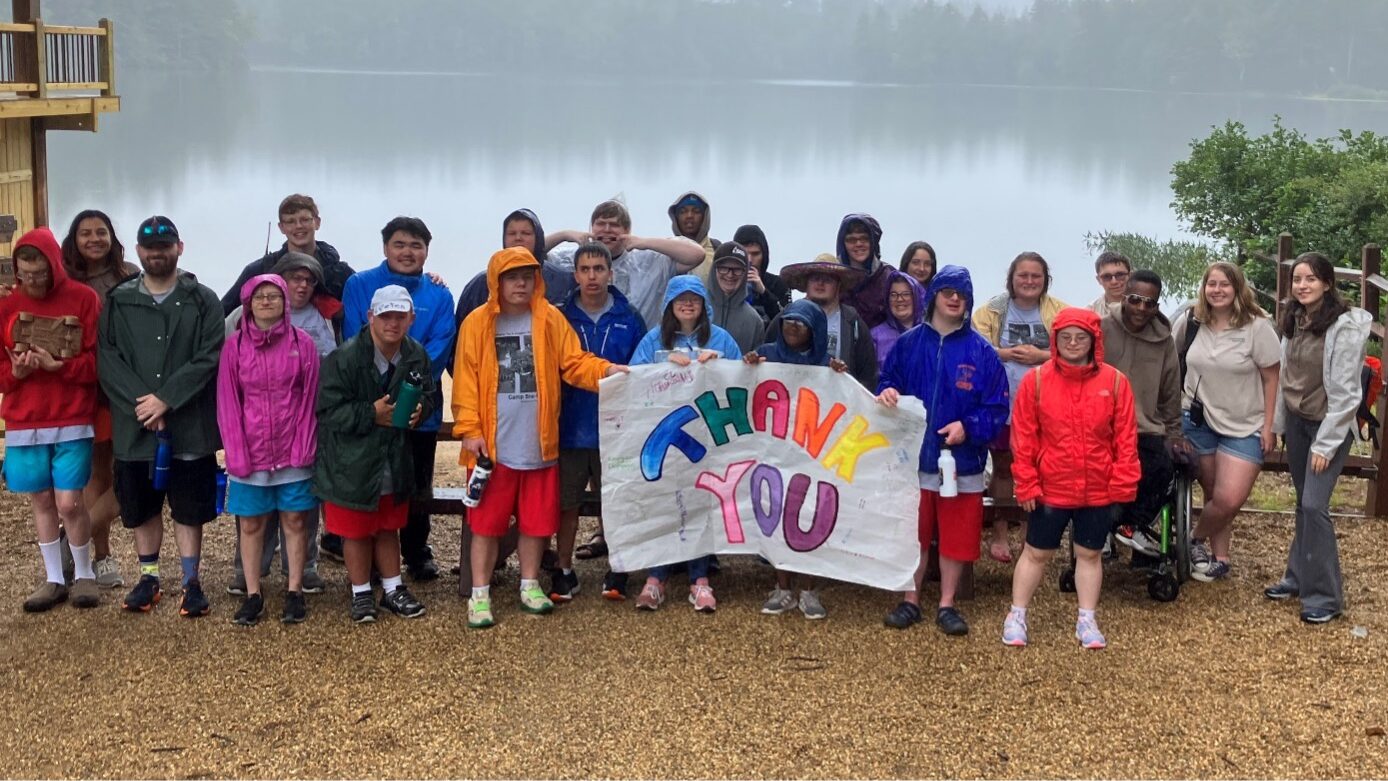 Group of campers holding a thank you banner at Camp Sno Mo.