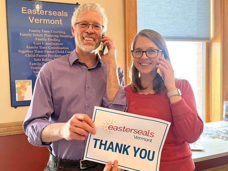 Paul and Erin holding a thank you sign at the Easterseals VT Barre office