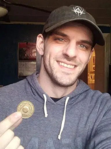 Joe holding a sobriety coin.